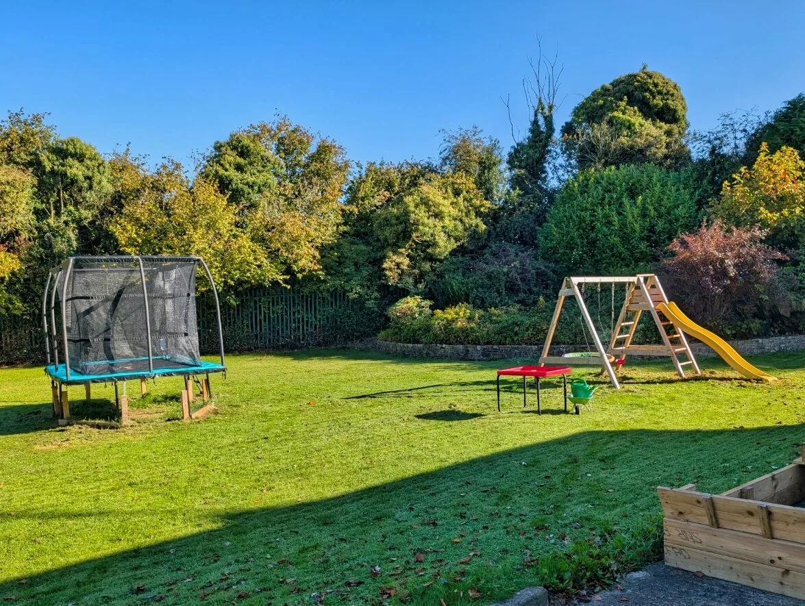 A garden with a trampoline and swings